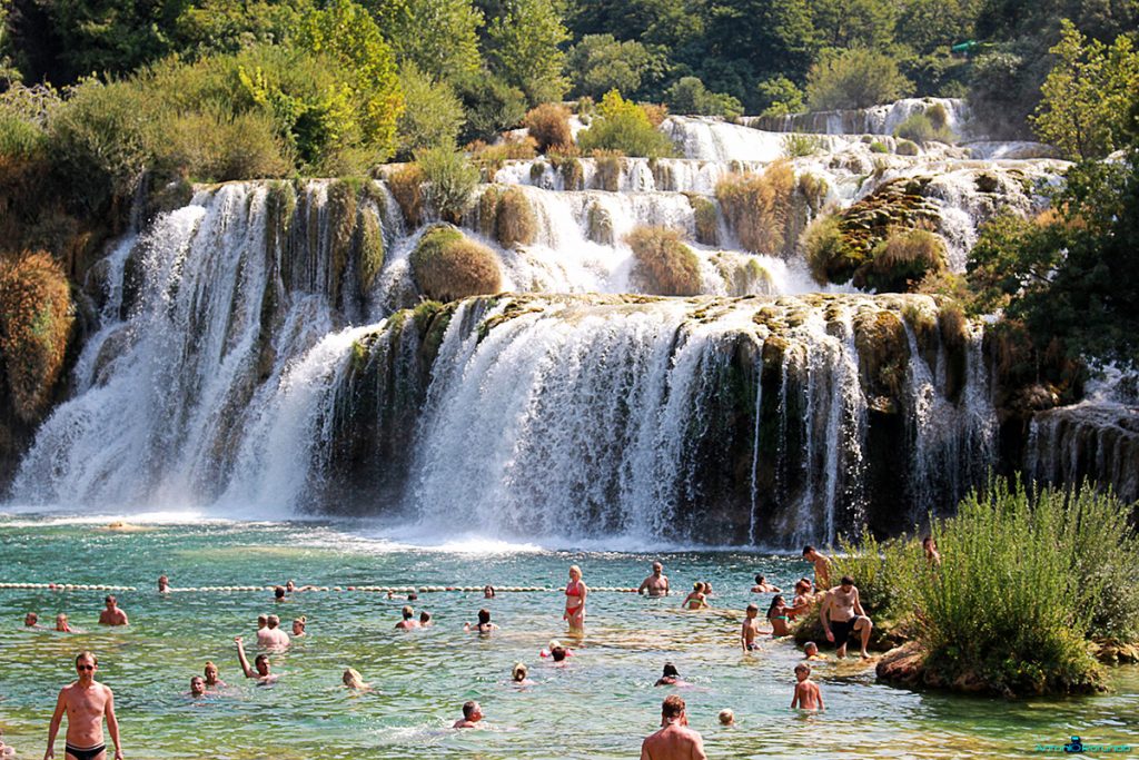 delle persone ai piedi della cascata di Skrandinski Buk, all'interno del Parco di Krka