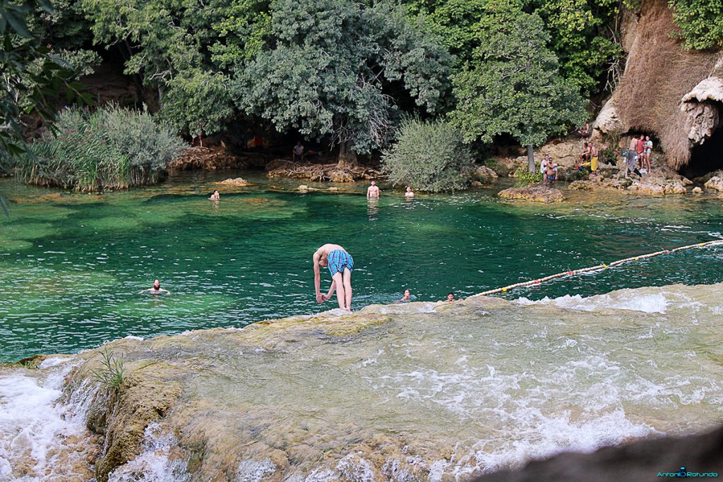 Ragazzo che si tuffa dalla cascata del parco di Krka