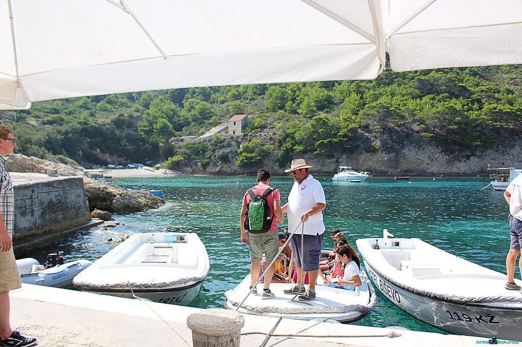 Durante il mio viaggio in Croazia, un uomo con un cappello aiuta un ragazzo a salire su una barca