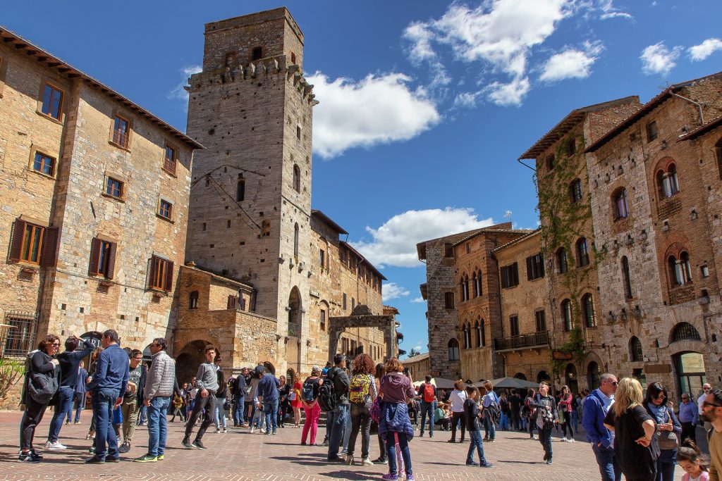 una piazza gremita di persone che osservano cosa vedere a San Gimignano