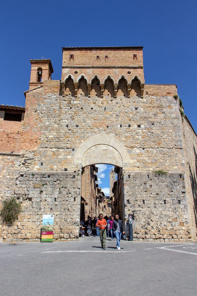 porta medievale con persone a piedi che la attraversano, ecco cosa vedere a San Gimignano