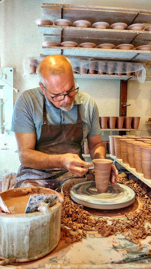 un ceramista che modella l'argilla sopra un tornio, ecco cosa vedere a San Gimignano