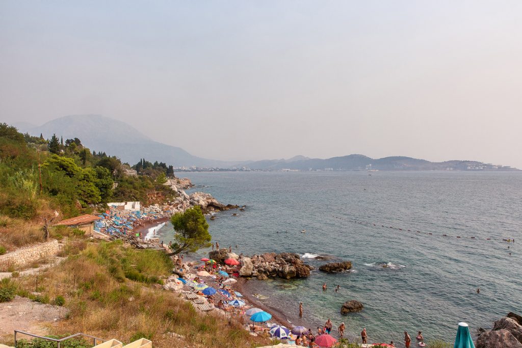 Uno scorcio di una spiaggia con ombrelloni e sdraio in riva al mare durante il viaggio in Montenegro