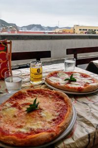 Arrivare a Ponza e andare a mangiare nella pizzeria rosticceria ponzese sul via del corso con vista mare
